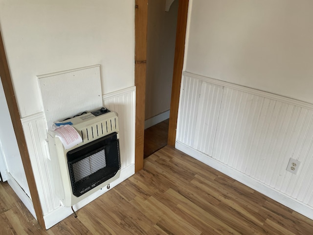 1431 Indian River Rd, Addison, ME 04606 - detailed view of heating unit, wainscoting, wood finished floors, and a decorative wall