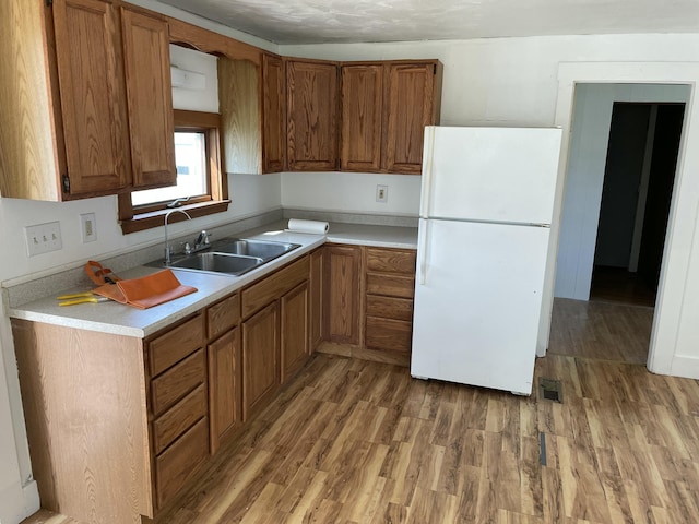 1431 Indian River Rd, Addison, ME 04606 - kitchen with freestanding refrigerator, light wood-type flooring, brown cabinets, and light countertops