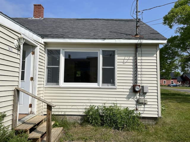 1431 Indian River Rd, Addison, ME 04606 - view of home's exterior featuring roof with shingles, a lawn, and a chimney