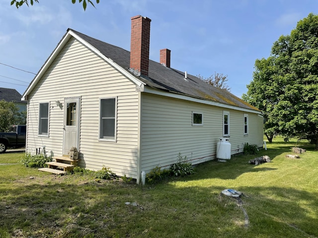 1431 Indian River Rd, Addison, ME 04606 - rear view of property with entry steps, a chimney, and a lawn