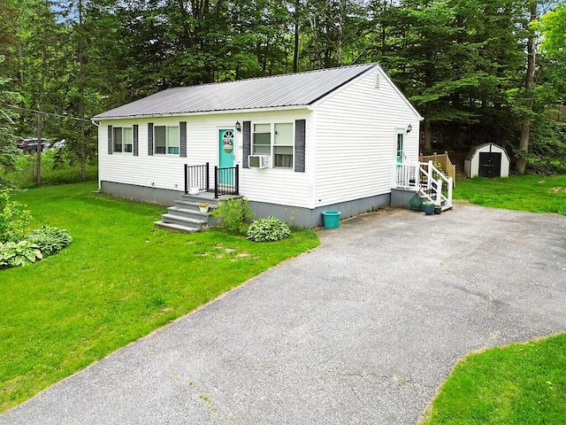 154 Rideout Ave, Lewiston, ME 04240 - view of front of property with a metal roof, a front lawn, a storage shed, and cooling unit