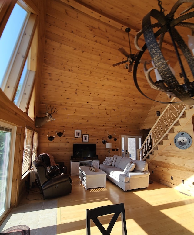 67 Upper Narrows Rd, Long Pond Twp, ME 04945 - living area featuring a towering ceiling, wooden walls, stairs, and wood finished floors