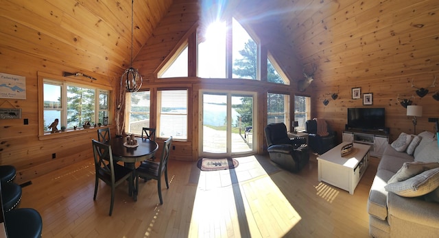 67 Upper Narrows Rd, Long Pond Twp, ME 04945 - dining area with wood walls, light wood-style floors, high vaulted ceiling, and wooden ceiling