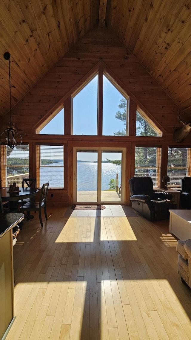67 Upper Narrows Rd, Long Pond Twp, ME 04945 - living area with wooden ceiling, a chandelier, high vaulted ceiling, plenty of natural light, and a water view