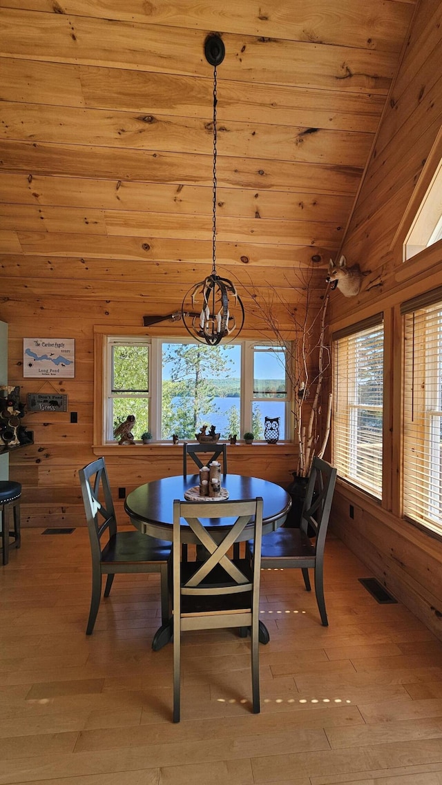 67 Upper Narrows Rd, Long Pond Twp, ME 04945 - dining area featuring vaulted ceiling, a chandelier, wood walls, light wood-style floors, and wood ceiling