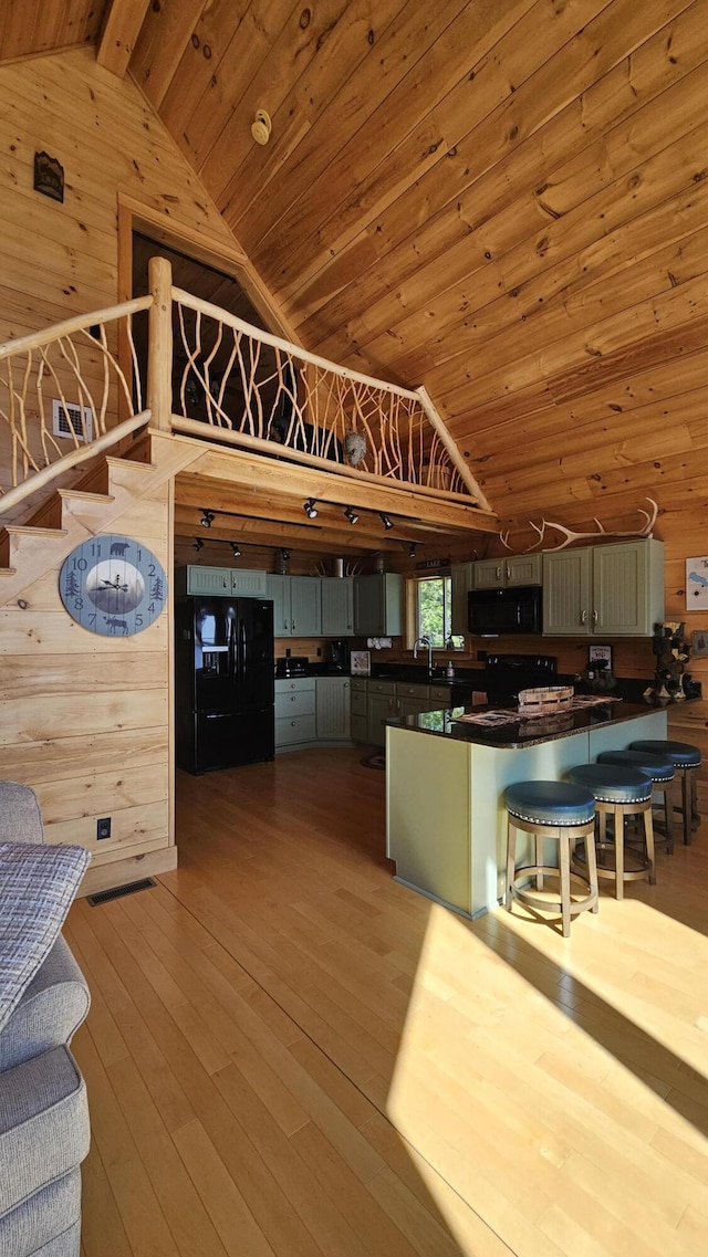 67 Upper Narrows Rd, Long Pond Twp, ME 04945 - kitchen featuring black appliances, wooden walls, lofted ceiling, dark countertops, and wood ceiling