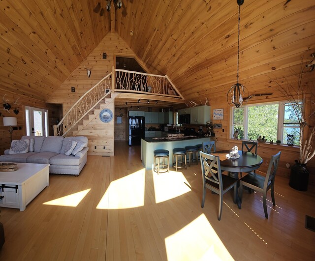67 Upper Narrows Rd, Long Pond Twp, ME 04945 - living room with wood walls, wooden ceiling, stairs, high vaulted ceiling, and a chandelier