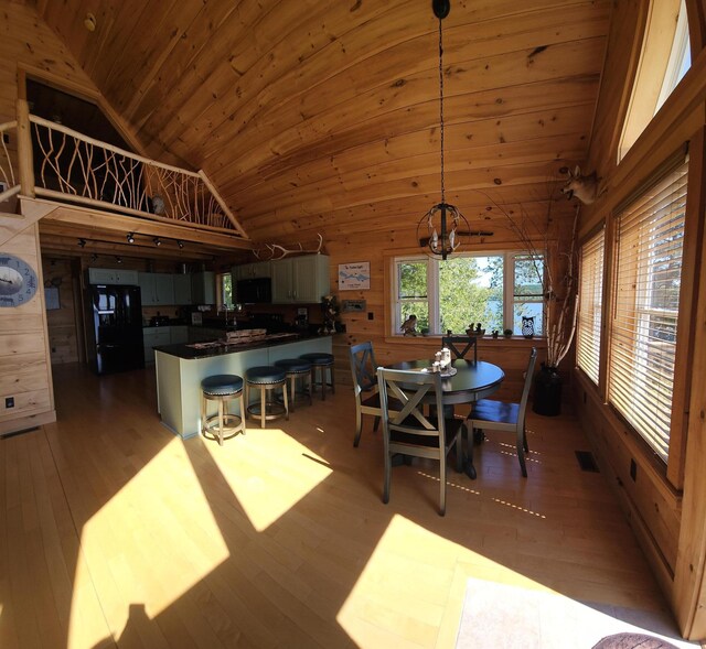 67 Upper Narrows Rd, Long Pond Twp, ME 04945 - dining space with vaulted ceiling, wood ceiling, wood-type flooring, wooden walls, and a chandelier