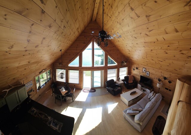 67 Upper Narrows Rd, Long Pond Twp, ME 04945 - living room featuring wooden walls, wooden ceiling, wood finished floors, and high vaulted ceiling