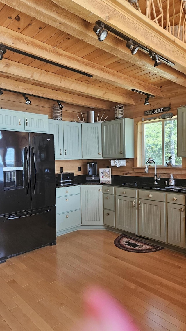 67 Upper Narrows Rd, Long Pond Twp, ME 04945 - kitchen with black fridge, dark countertops, light wood finished floors, track lighting, and a wooden ceiling with exposed beams