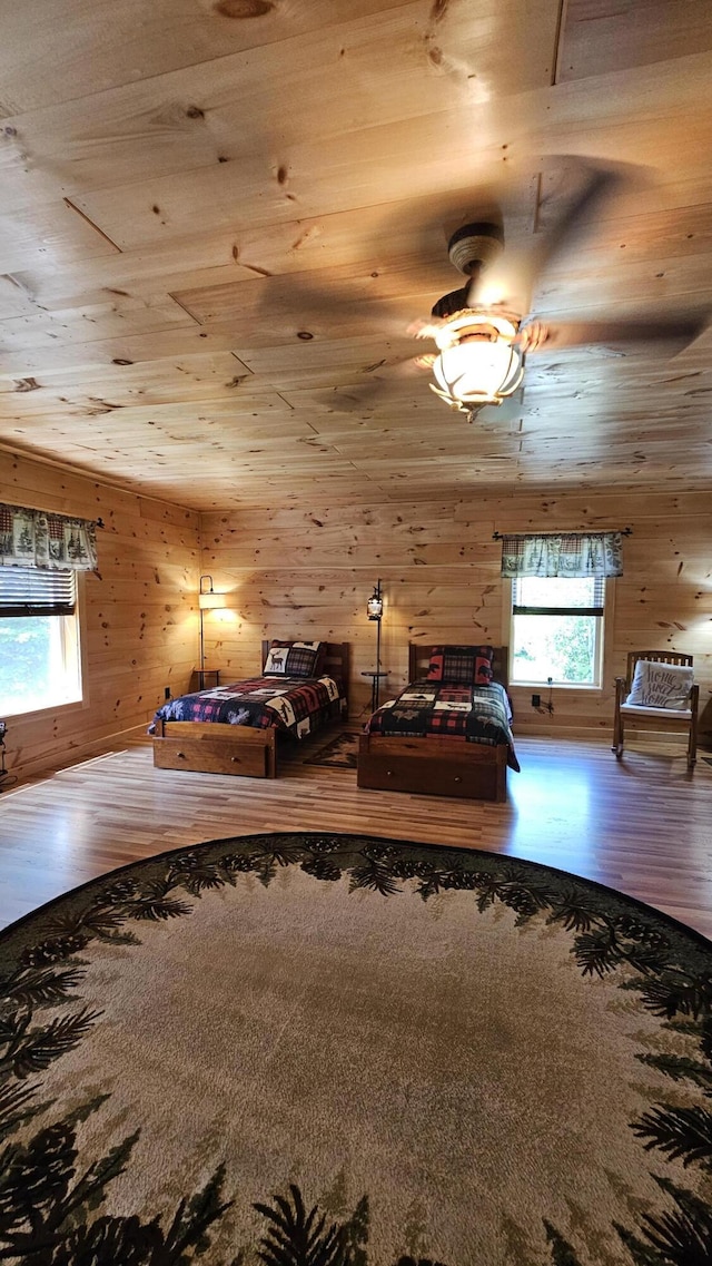 67 Upper Narrows Rd, Long Pond Twp, ME 04945 - bedroom featuring wood finished floors, multiple windows, wood walls, and wooden ceiling