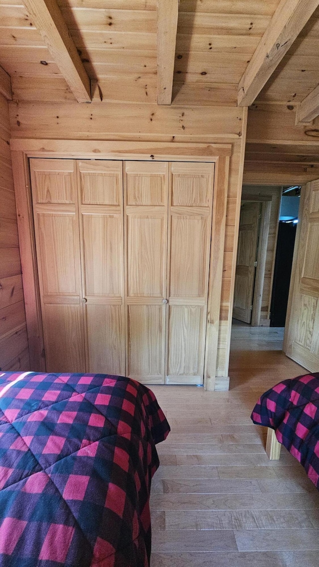 67 Upper Narrows Rd, Long Pond Twp, ME 04945 - bedroom with a wood ceiling with exposed beams, hardwood / wood-style floors, and wood walls