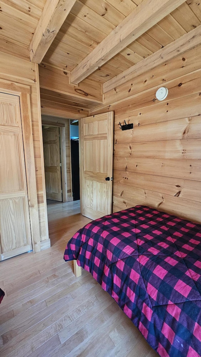 67 Upper Narrows Rd, Long Pond Twp, ME 04945 - bedroom with wooden walls, wood finished floors, and a wooden ceiling with exposed beams