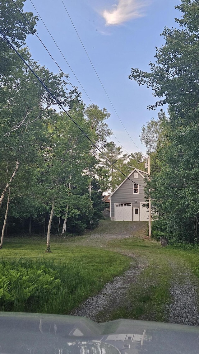 67 Upper Narrows Rd, Long Pond Twp, ME 04945 - view of yard with a detached garage, dirt driveway, a barn, and an outdoor structure
