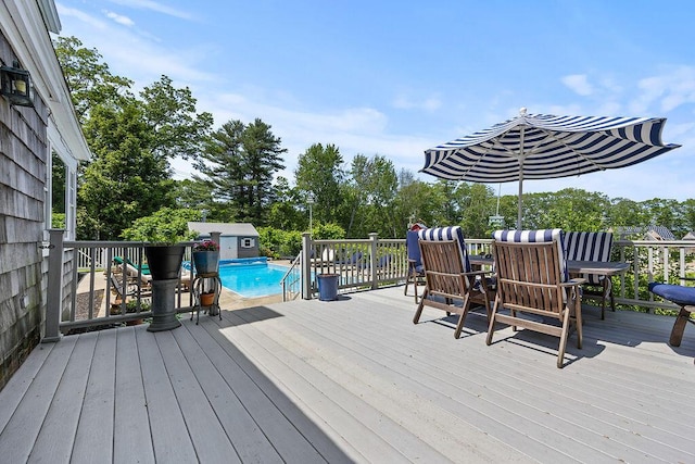 555 Pool St, Biddeford, ME 04005 - wooden deck with a storage shed, outdoor dining space, and view of wooded area