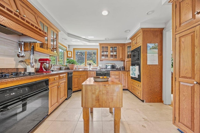 555 Pool St, Biddeford, ME 04005 - kitchen featuring black appliances, backsplash, glass insert cabinets, a center island, and recessed lighting