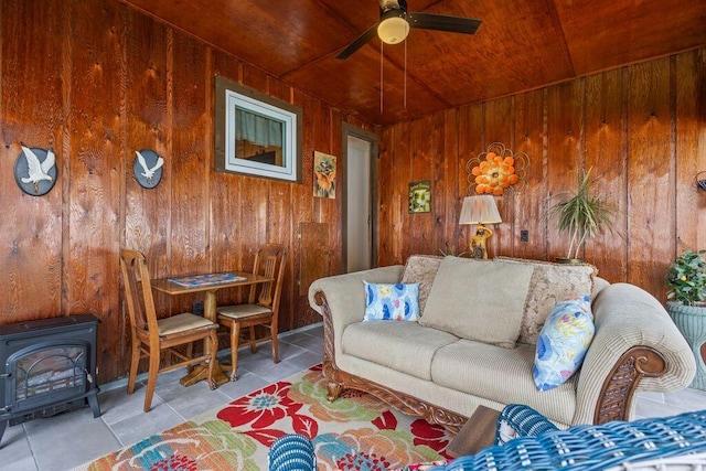 1522 Richville Rd, Standish, ME 04084 - living room featuring wooden ceiling, wooden walls, tile patterned floors, a wood stove, and ceiling fan