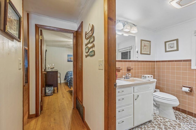 1522 Richville Rd, Standish, ME 04084 - half bathroom with vanity, ornamental molding, tile walls, wood finished floors, and a wainscoted wall
