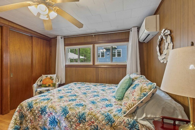 1522 Richville Rd, Standish, ME 04084 - bedroom with a wall mounted air conditioner, wood walls, a ceiling fan, a closet, and wood finished floors