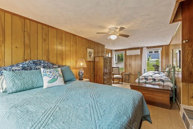 1522 Richville Rd, Standish, ME 04084 - bedroom featuring a wall unit AC, wood walls, wood finished floors, and ceiling fan