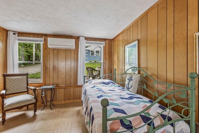 1522 Richville Rd, Standish, ME 04084 - bedroom featuring an AC wall unit, light wood-type flooring, multiple windows, wood walls, and a textured ceiling