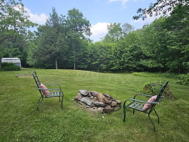 28 Varnum Pond Rd, Temple, ME 04984 - view of grassy yard with a fire pit and a view of trees