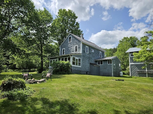 28 Varnum Pond Rd, Temple, ME 04984 - rear view of property featuring a chimney, a lawn, and a fire pit