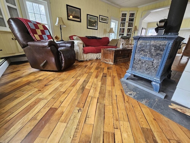 28 Varnum Pond Rd, Temple, ME 04984 - living room featuring hardwood / wood-style flooring, a wood stove, ornamental molding, and wooden walls