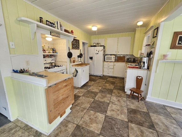 28 Varnum Pond Rd, Temple, ME 04984 - kitchen featuring white appliances, open shelves, light countertops, dark stone finish floors, and wooden walls