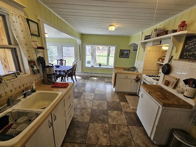 28 Varnum Pond Rd, Temple, ME 04984 - kitchen featuring backsplash, wood walls, dark stone finish floors, and a baseboard heating unit