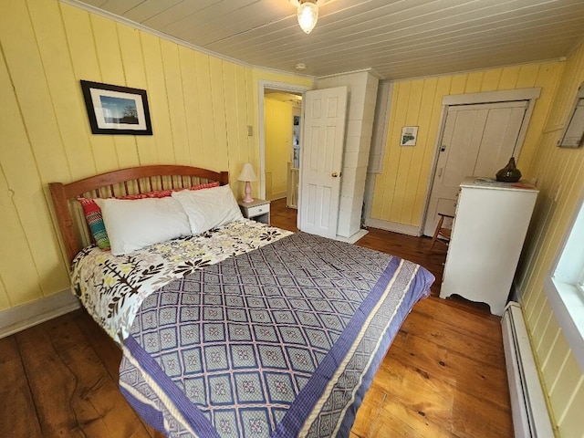 28 Varnum Pond Rd, Temple, ME 04984 - bedroom featuring baseboard heating, wood finished floors, wood walls, and crown molding