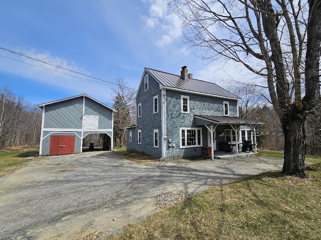 28 Varnum Pond Rd, Temple, ME 04984 - rear view of property with a chimney, driveway, covered porch, a metal roof, and a standing seam roof