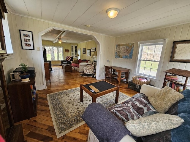28 Varnum Pond Rd, Temple, ME 04984 - living area with arched walkways, ornamental molding, wood finished floors, wooden walls, and a ceiling fan