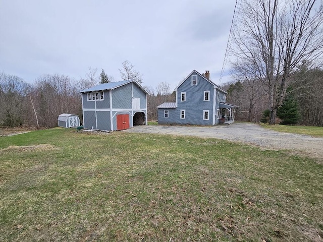 28 Varnum Pond Rd, Temple, ME 04984 - view of side of property with a storage shed, a chimney, a lawn, and driveway