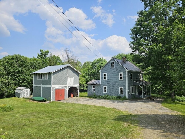 28 Varnum Pond Rd, Temple, ME 04984 - view of side of property with a storage unit, a lawn, a chimney, and dirt driveway