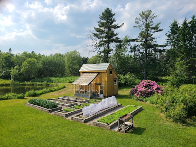 163 Ayer Ridge Rd, Freedom, ME 04941 - view of grassy yard with a greenhouse, an outbuilding, a vegetable garden, a water view, and a view of trees