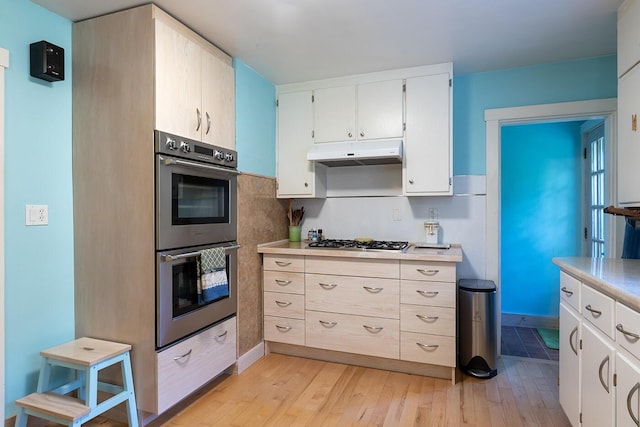 184 Mountain St, Camden, ME 04843 - kitchen featuring appliances with stainless steel finishes, under cabinet range hood, light wood-style flooring, and light countertops