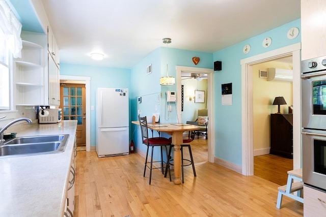 184 Mountain St, Camden, ME 04843 - kitchen with white appliances, open shelves, white cabinetry, and light wood finished floors