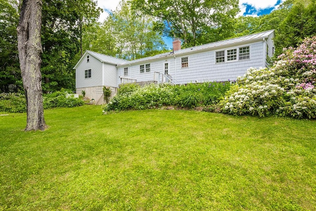 184 Mountain St, Camden, ME 04843 - back of property featuring a chimney, a standing seam roof, a lawn, and a metal roof