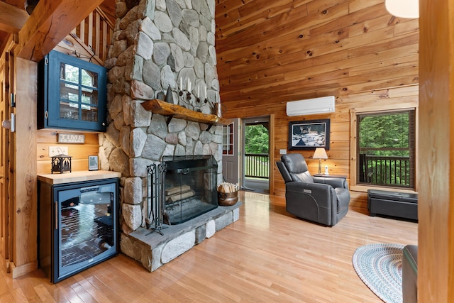 50 Flagg Way, Fayette, ME 04349 - living area with beverage cooler, wood finished floors, a wall mounted AC, a fireplace, and vaulted ceiling