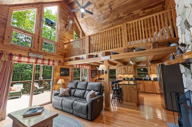 50 Flagg Way, Fayette, ME 04349 - living area with high vaulted ceiling, a ceiling fan, light wood-style floors, wooden ceiling, and wood walls