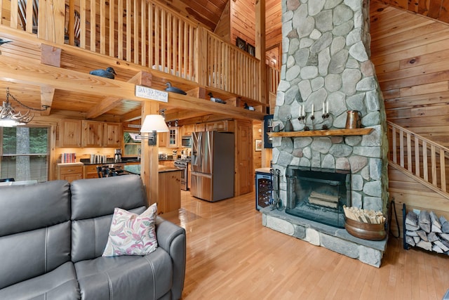 50 Flagg Way, Fayette, ME 04349 - living room with wooden walls, light wood finished floors, a chandelier, wood ceiling, and a fireplace
