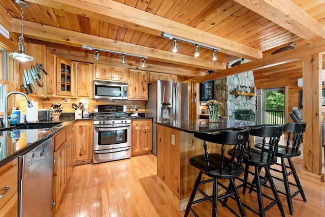 50 Flagg Way, Fayette, ME 04349 - kitchen featuring appliances with stainless steel finishes, rail lighting, light wood-type flooring, a wooden ceiling with exposed beams, and a center island