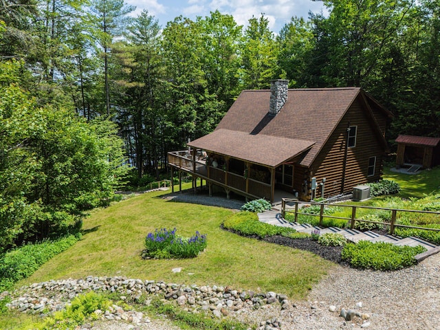 50 Flagg Way, Fayette, ME 04349 - view of front of property with log exterior, a front yard, a chimney, and a wooden deck