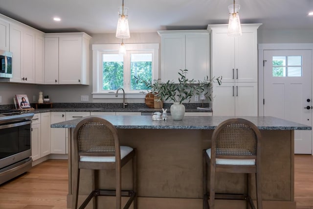 59 Sagamore Dr Lot 28, Phippsburg, ME 04562 - kitchen featuring stainless steel appliances, a center island, a kitchen bar, white cabinets, and recessed lighting