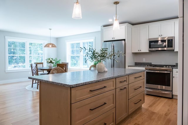 59 Sagamore Dr Lot 28, Phippsburg, ME 04562 - kitchen with stainless steel appliances, light wood-style floors, a center island, decorative light fixtures, and white cabinetry