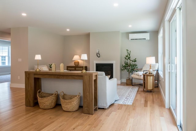 59 Sagamore Dr Lot 28, Phippsburg, ME 04562 - living area featuring a wall unit AC, light wood-type flooring, recessed lighting, and a glass covered fireplace