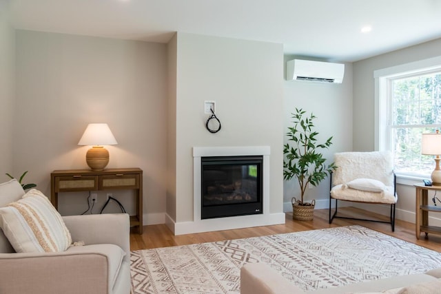59 Sagamore Dr Lot 28, Phippsburg, ME 04562 - living area featuring a wall mounted air conditioner, a glass covered fireplace, wood finished floors, and recessed lighting