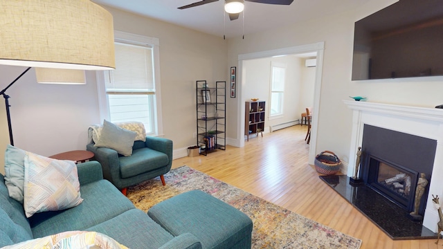 295 French St, Bangor, ME 04401 - living room featuring wood finished floors, a glass covered fireplace, a ceiling fan, a baseboard heating unit, and an AC wall unit