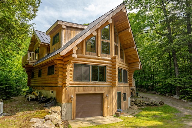 320 Commons Dr, Bridgton, ME 04009 - view of front facade with log siding, a balcony, a metal roof, a standing seam roof, and a garage